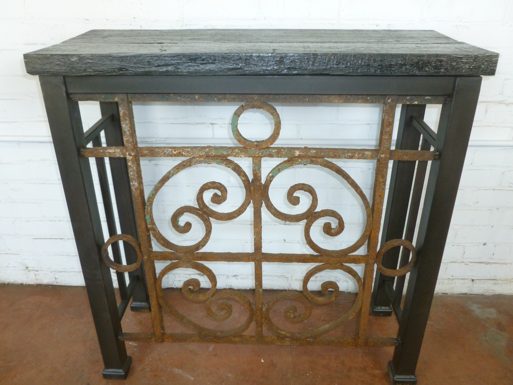 Custom iron console table by Ferro Designs LLC with a barnwood top and a dark iron base finish.