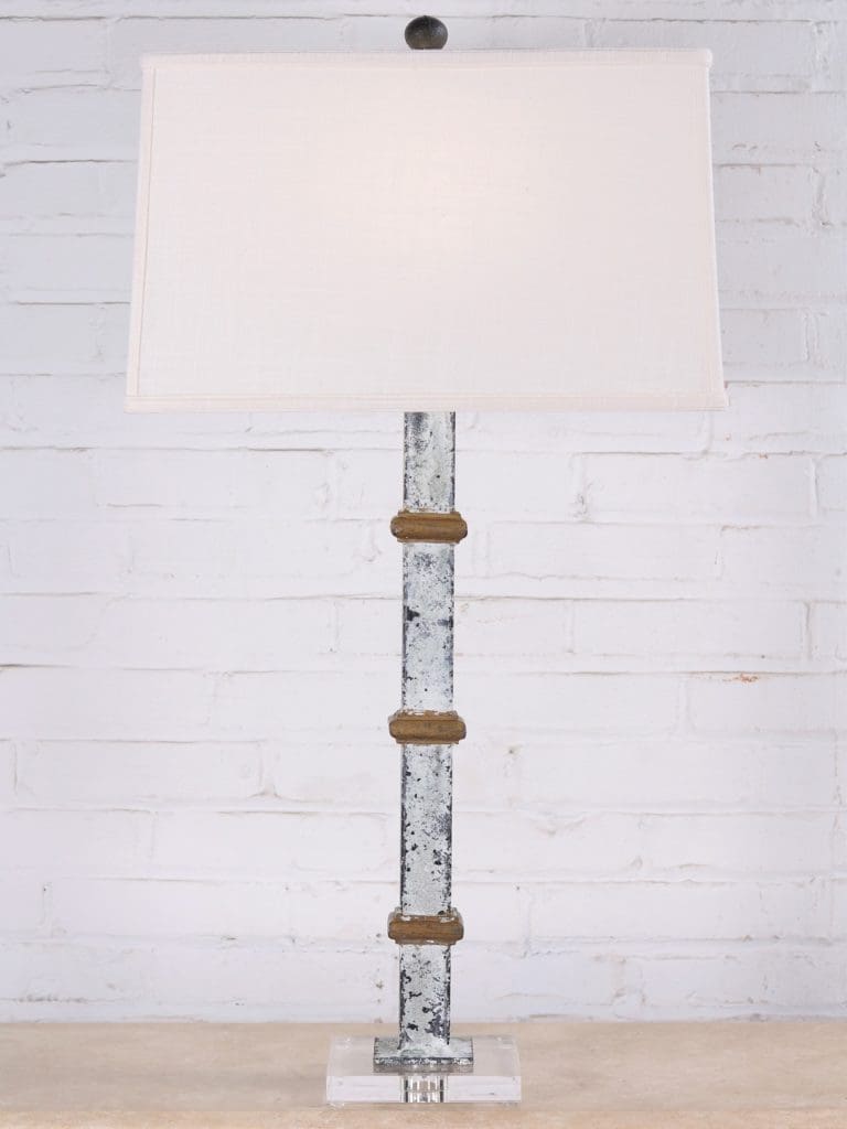 White metal table lamp with gold accents and an acrylic base. Paired with a 17 inch linen lamp shade.