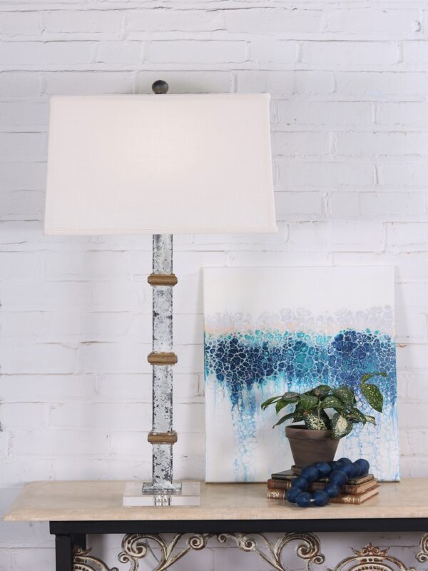 White metal table lamp with gold accents and an acrylic base. Paired with a 17 inch linen lamp shade.